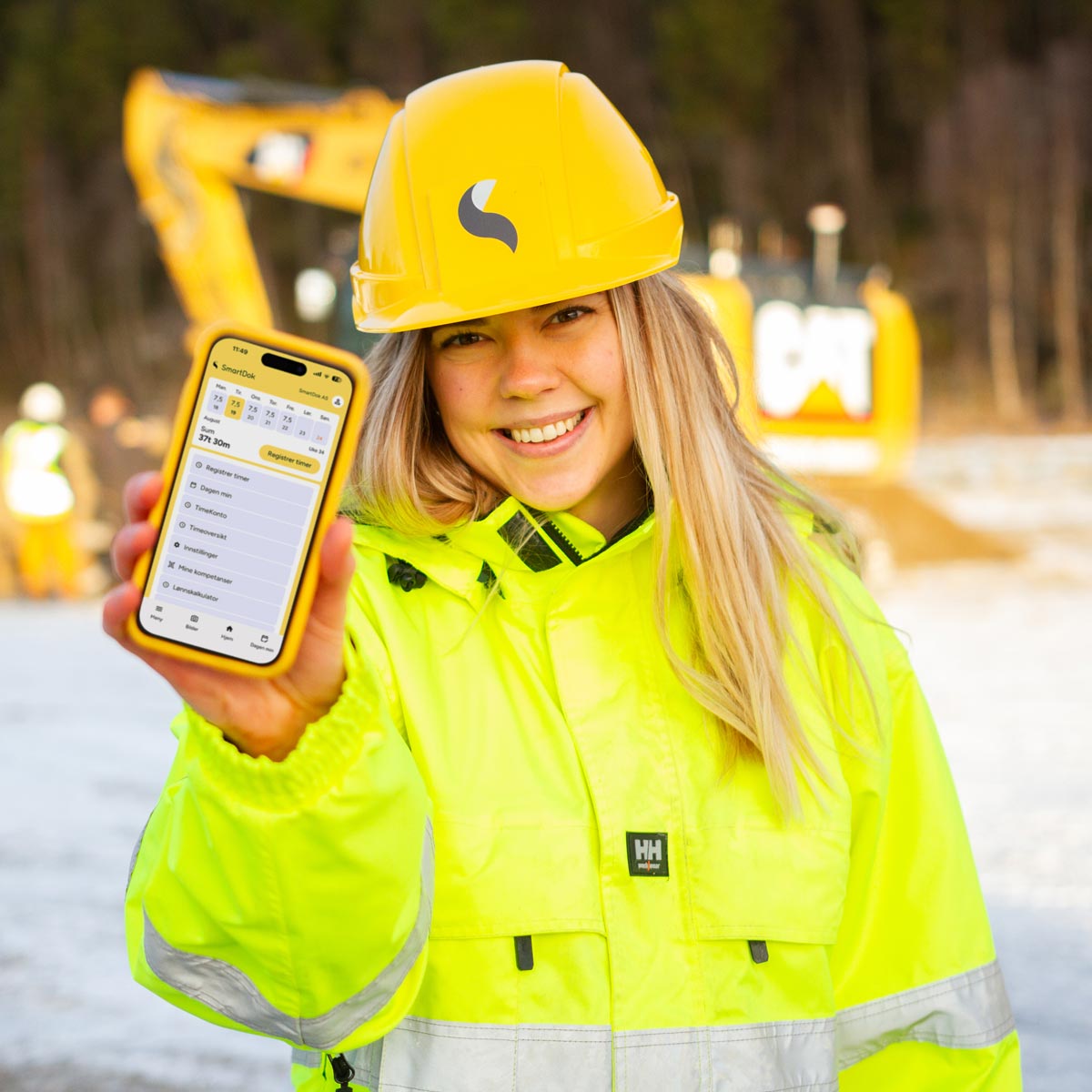 Jente foran gravemaskin med app